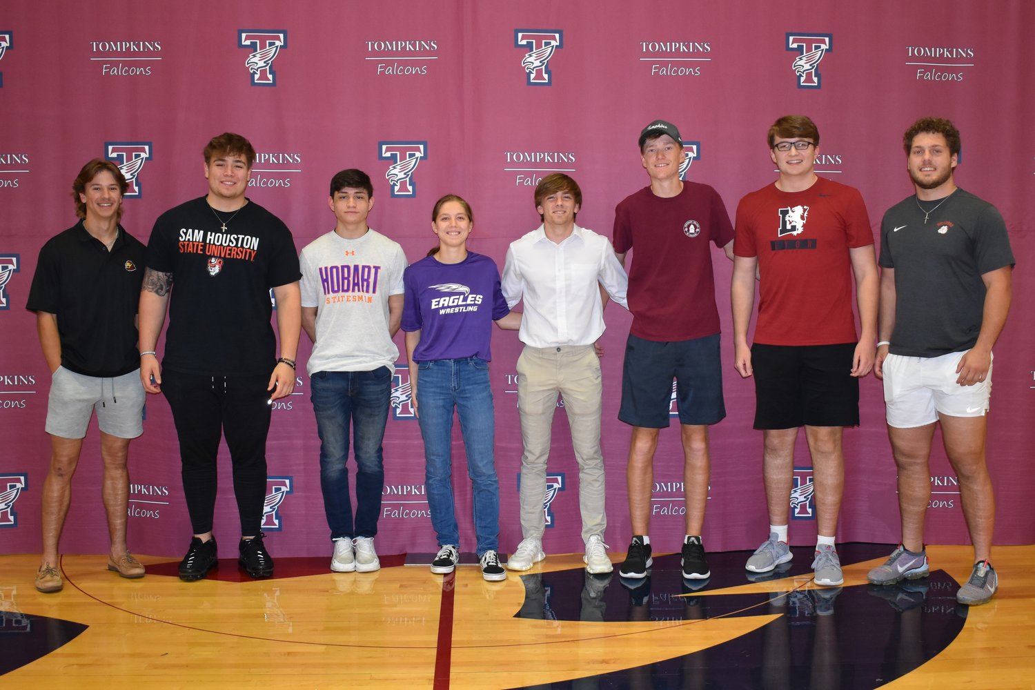 Tompkins student athletes pose for a photo during National Signing Day.